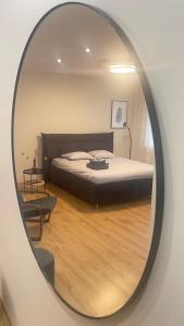 帕内韦日斯S&A apartamentai的镜子反射着卧室,卧室里配有一张床