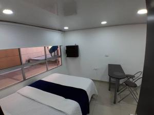 波哥大Apartamento Grupal, Chapinero的一间卧室配有一张床、一张书桌和一个窗户。