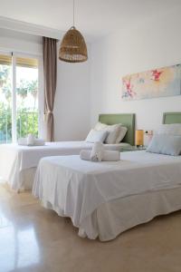 福恩吉罗拉Marina del Sol apartment by Wyndham的卧室设有2张床和白色的墙壁。