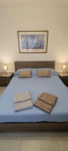 阿其利亚Casa Ricci的蓝色的床,上面有两条毛巾