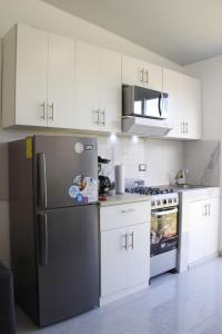 圣米格尔Residencial Privada Nueva San miguel, casa Flores的厨房配有白色橱柜和黑色冰箱。