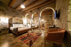 格雷梅Caverna Hotel Premium Caves的一间卧室设有两张床和石墙