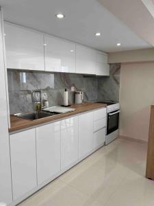 米蒂利尼Minimal Cozy Apartment的厨房配有白色橱柜和水槽