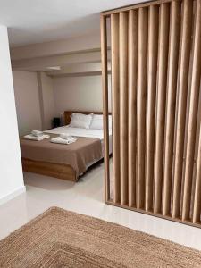 米蒂利尼Minimal Cozy Apartment的一间卧室设有一张床和一个大型滑动玻璃门