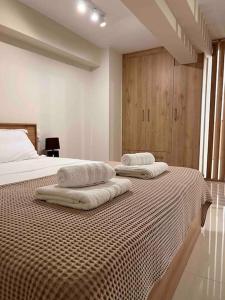 米蒂利尼Minimal Cozy Apartment的卧室配有2条毛巾,位于床上