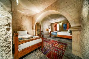 格雷梅Caverna Hotel Premium Caves的石头客房设有一间带两张床的卧室