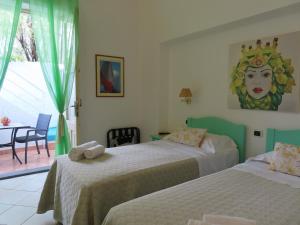 斯特龙博利Stromboli Trekking Accommodation - Room and Excursion for 2 included的一间带两张床的卧室,配有一个女人的雕像