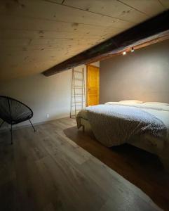 LevassaixAppartement Chalet Petzu - 6 Pers - Parking - Ski au pied的一间卧室配有一张床、梯子和椅子