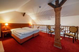 布拉格Hotel Raffaello Prague的一间卧室设有一张床,阳台上设有木十字架