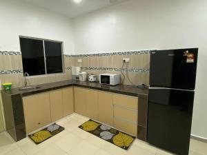 关丹Shaleishah Homestey的厨房配有黑色冰箱和微波炉。