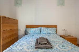 塞维利亚Apartamento en Sevilla vacacional的卧室里一张带毯子的床和梳妆台