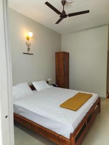 卡尔佩特塔SN Residency的一间卧室配有一张带吊扇的床