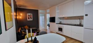 哥本哈根Modern, fully equipped flat的一间厨房,内设白色橱柜和一张白色桌子