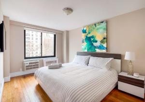 纽约Amazing 4 Bedroom Apartment In Chambers Street的卧室配有一张床,墙上挂有绘画作品