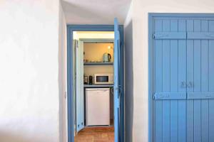赞布热拉-杜马尔陶利尔赫达德酒店的通往带冰箱的厨房的蓝色门