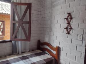 格拉瓦塔Casa 04 do Condomínio Privê Portal das Flores的一间设有椅子和白色砖墙的房间