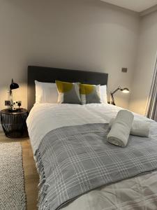 伦敦Richardson Deluxe Apartments的卧室配有一张带灰色和白色棉被的床