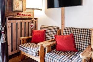 科瓦拉因巴迪亚Chalet Sassongher II的客房内的两把椅子和红色枕头
