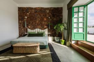 阿索马达Hotel Cesar Lanzarote的一间卧室设有一张床和砖墙