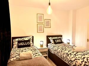 巴尔金Modern Renovated 2-Bedroom House的一间卧室配有两张带枕头的床。