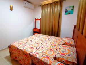 特鲁欧克比赫斯Sand Castle Villa的一间卧室配有一张带橙色和白色棉被的床