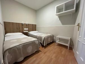 马德里Apartamentos Mayor Centro的小房间设有两张床和一张婴儿床