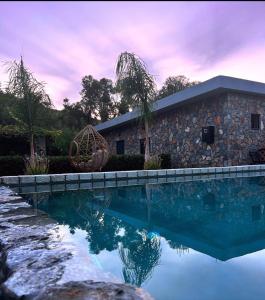 阿彻奇洛斯Aithonas Villa的一座石头房子,前面设有一个游泳池