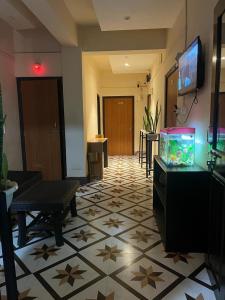 因帕尔OYO Flagship The Thangal Hotel的一间客厅,在瓷砖地板上设有一个鱼缸