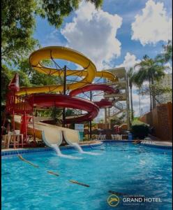 卡达斯诺瓦斯Golden Dolphin Grand Hotel的度假村游泳池的水滑梯