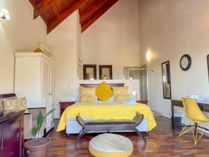 比勒陀利亚Amoris Guesthouse In Waterkloof Ridge的一间卧室配有黄色的床和两把椅子