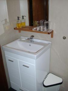 波尔图可沃洛公寓的一个带水槽和玻璃架的浴室