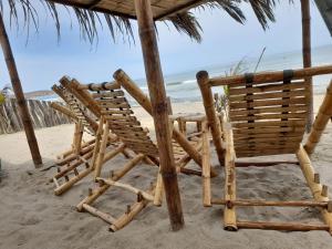 卡诺阿斯德蓬萨尔Las Fragatas Casa Hotel的一组椅子坐在海滩上