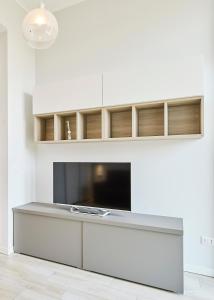 米兰Monviso Mono - Exclusive Apartment的一间带电视和白色墙壁的客厅