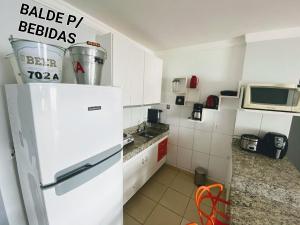 热河市Rio Quente GO Apto 7 Pessoas 2 Qtos的厨房配有白色冰箱和微波炉