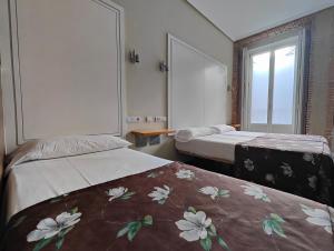 马德里马德里旅馆的酒店客房设有两张床和窗户。