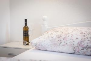 塞尼Apartments Luka的一张带一瓶葡萄酒和两杯酒的床