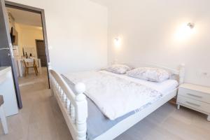 塞尼Apartments Luka的卧室内的一张带两个枕头的白色床