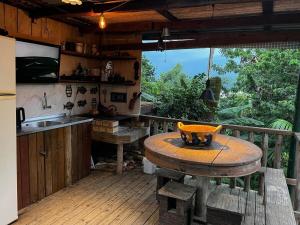 塞尔苏拉穆斯州长镇Espetacular! Casa em com vista deslumbrante的带木桌的厨房和带台面的厨房