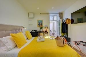马赛Boutique Hôtel Provencia的一间卧室配有黄色的大床和黄色枕头