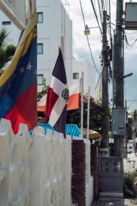 蓬塔卡纳Riviera Punta Cana Eco Travelers的建筑物旁的栅栏上悬挂两面旗帜