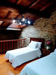 特里亚卡斯特拉Casa Pacios by M de Santiago的一间卧室设有两张床和石墙