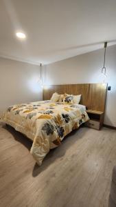 昆卡302 Departamento La Terraza的一间卧室配有一张大床和木制床头板