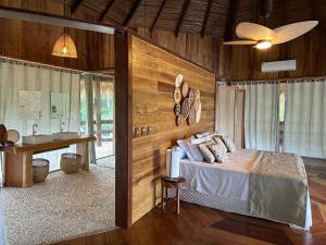 Autazes亚马逊祖马酒店的一间卧室设有木墙、一张床和一张书桌