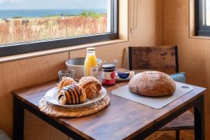 圣安德鲁斯Rustic Cabins, sea views from rewilded farm的一张桌子,上面放着一盘面包和一瓶橙汁