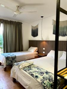 库库塔Hotel Macaw Cúcuta的酒店客房设有两张床和窗户。