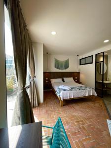 库库塔Hotel Macaw Cúcuta的一间卧室设有一张床和一个大窗户