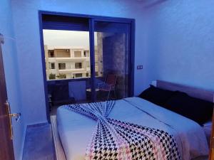 曼苏里亚Bel appartement à Malaga Beach El Mansouria的一间卧室设有一张床和一个大窗户