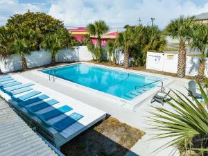 巴拿马城海滩Bahama Breeze Suites的一座带白色围栏和棕榈树的大型游泳池