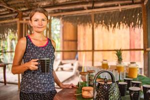 伊基托斯Aparthotel Ayahuaska for SOLO travelers的站在厨房里拿着杯子的女人