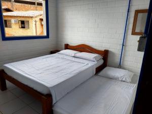 马拉戈日Chalé das Conchas的一间卧室设有两张床和窗户。